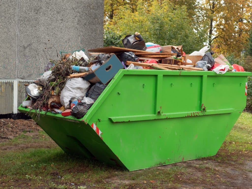 Green Skip which is full with waste